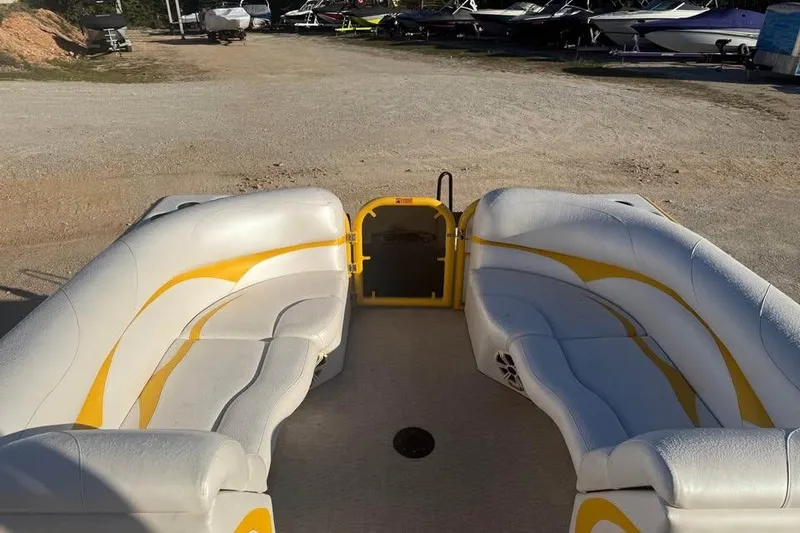 Slide: The Image of 2022 Aloha Pontoon Tropical 260 with white and yellow seating, docked on gravel. - 9