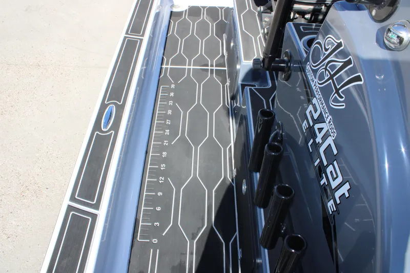 Slide: The Image of 2025 Mamba 24 Cat Elite boat deck with custom rod holders and measuring guide. - 16
