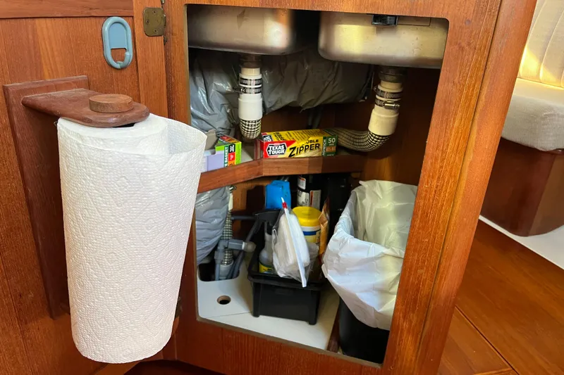 Slide: The Image of Under-sink storage in 1990 Hunter Legend 35.5 yacht with paper towel holder and supplies. - 10