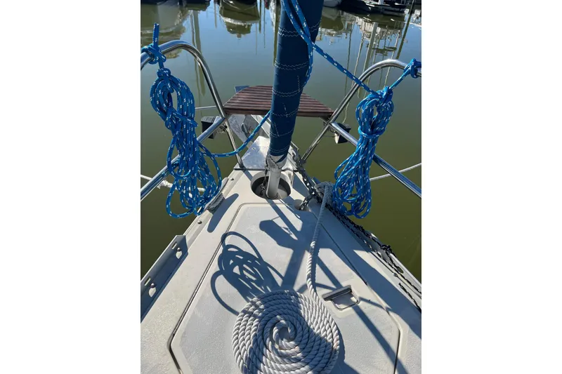 Slide: The Image of Deck view of 1990 Hunter Legend 35.5 sailboat with coiled ropes and marina background. - 12