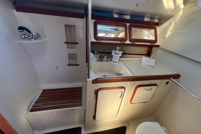 Slide: The Image of 1990 Hunter Legend 35.5 yacht bathroom with sink, mirror, and storage cabinets. - 20