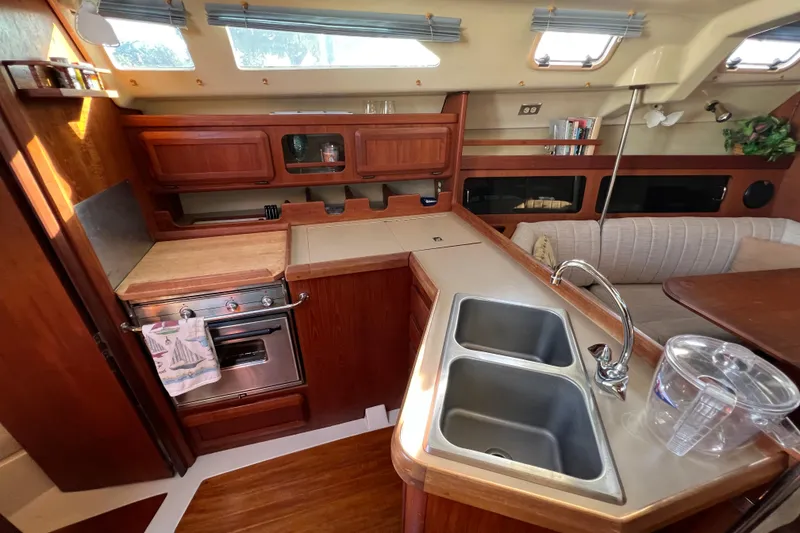 Slide: The Image of Interior of 1990 Hunter Legend 35.5 sailboat kitchen with stove, sink, and seating area. - 23