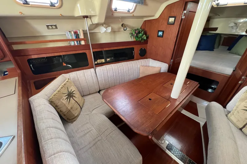 Slide: The Image of Cozy interior of 1990 Hunter Legend 35.5 sailboat with wooden table and cushioned seating. - 24