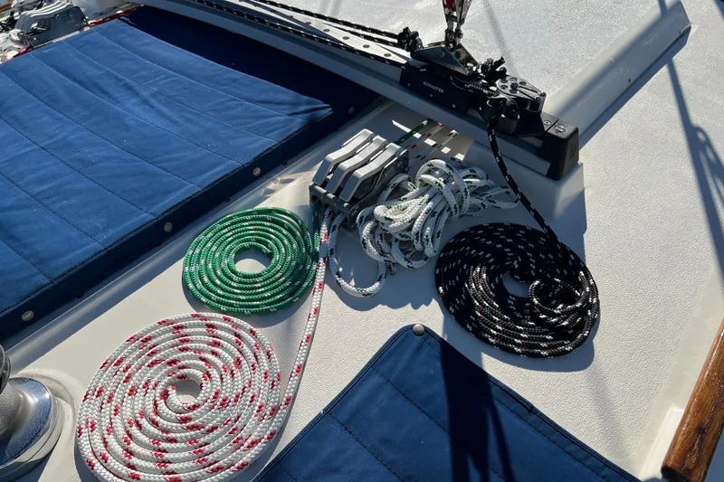 Slide: The Image of Deck of 1990 Hunter Legend 35.5 sailboat with coiled ropes and blue cushions. - 30