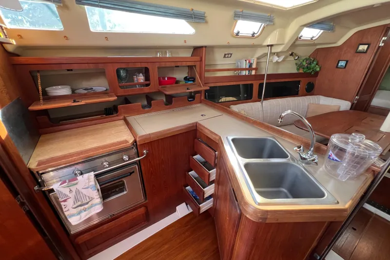 Slide: The Image of Interior of 1990 Hunter Legend 35.5 sailboat kitchen with wood cabinetry and dual sink. - 7