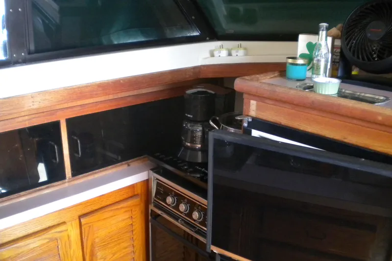 Slide: The Image of 1988 Mainship 40 Double Cabin kitchen with stove, coffee maker, and wooden cabinetry. - 16