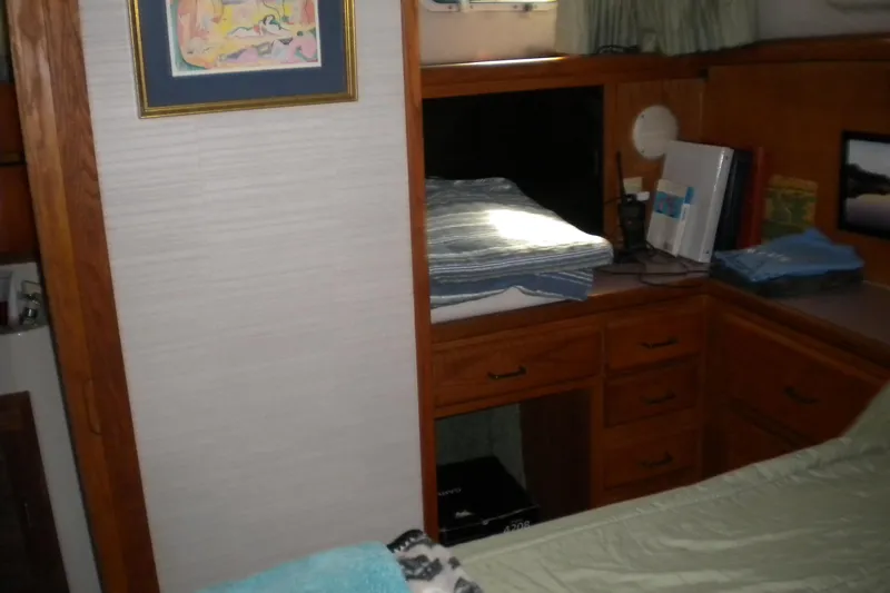 Slide: The Image of 1988 Mainship 40 Double Cabin interior with wooden cabinetry and cozy bedding. - 19