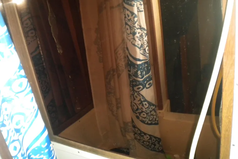 Slide: The Image of 1988 Mainship 40 Double Cabin bathroom with patterned shower curtain and wooden accents. - 32