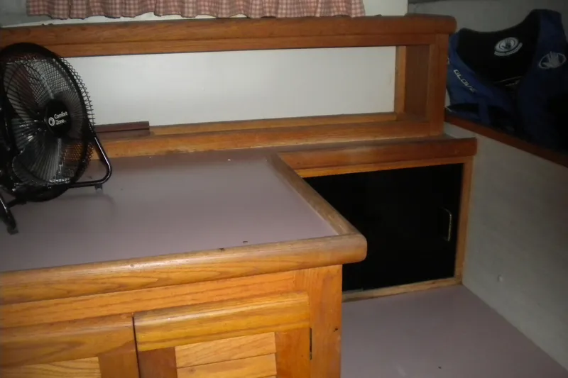 Slide: The Image of 1988 Mainship 40 Double Cabin interior with wooden cabinetry and a small fan. - 35
