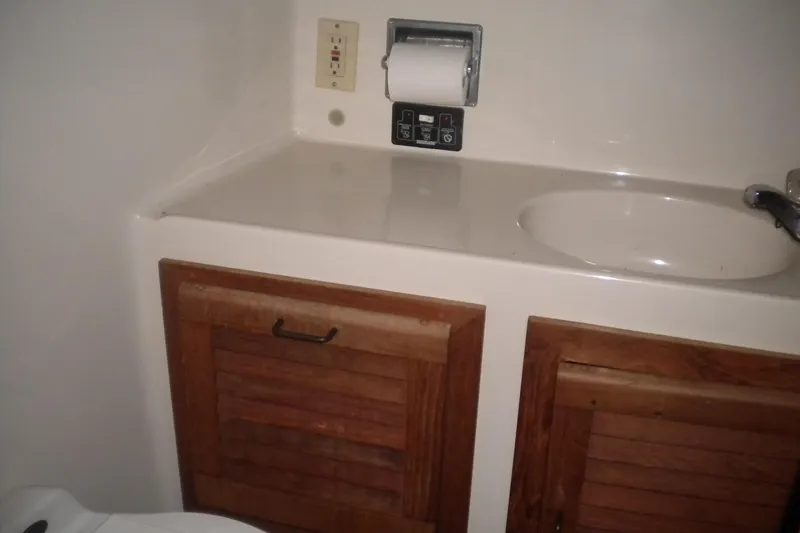 Slide: The Image of 1988 Mainship 40 Double Cabin bathroom with sink, wooden cabinets, and toilet paper holder. - 36
