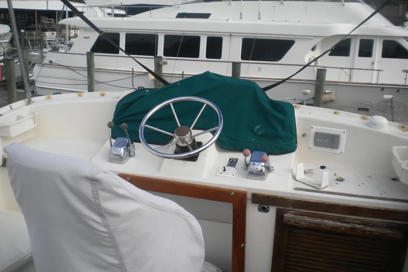 Slide: The Image of 1988 Mainship 40 Double Cabin helm with covered controls and steering wheel at marina. - 46