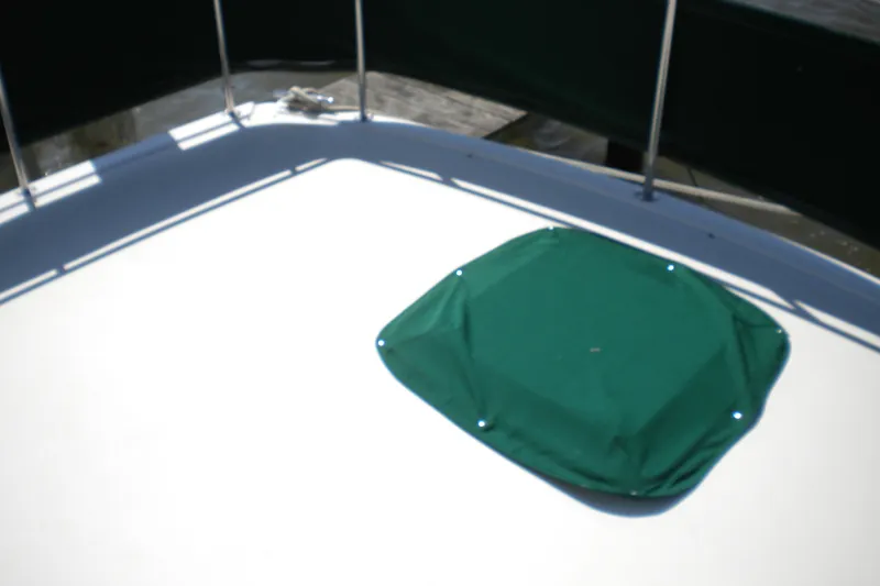 Slide: The Image of 1988 Mainship 40 Double Cabin deck with green cover and railing. - 6