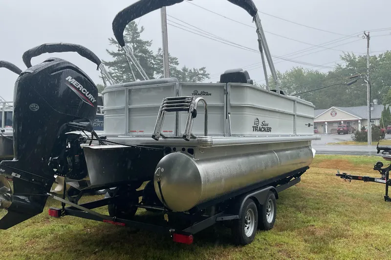 Slide: The Image of 2026 Sun Tracker PB 20 DLX pontoon boat on trailer in rainy outdoor setting. - 7
