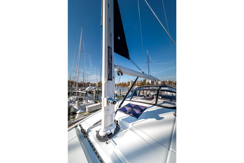 Slide: The Image of 2016 Jeanneau 64 sailboat deck with mast, docked in marina under clear blue sky. - 15