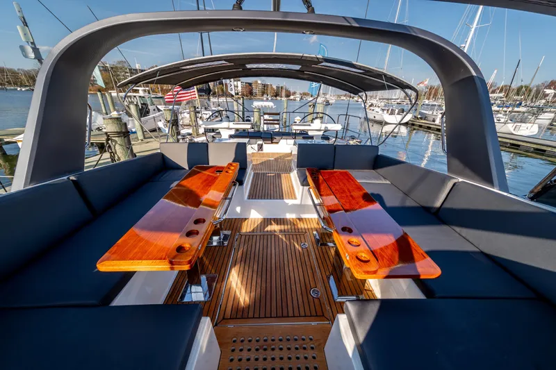 Slide: The Image of Luxurious 2016 Jeanneau 64 yacht deck with elegant seating and wooden tables. - 21