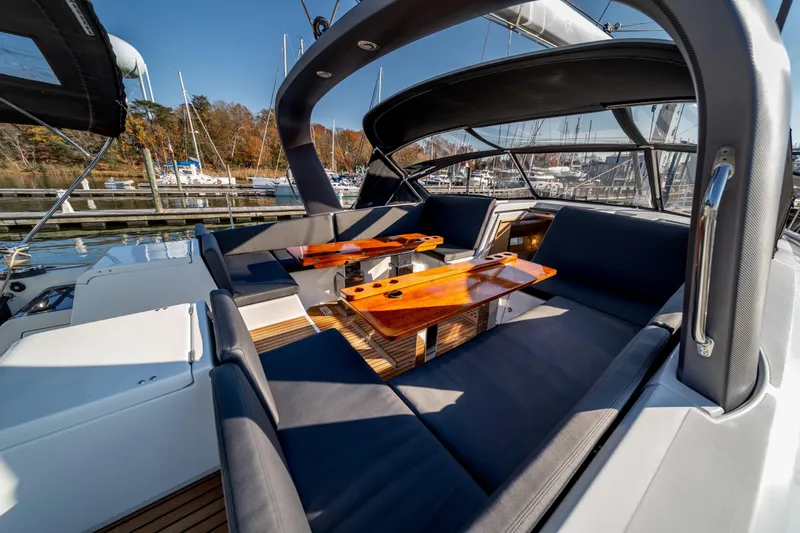 Slide: The Image of Luxurious 2016 Jeanneau 64 yacht cockpit with elegant seating and wooden tables. - 22