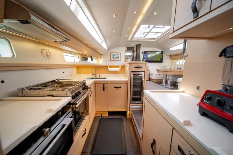 Slide: The Image of Luxurious interior of a 2016 Jeanneau 64 yacht, featuring a modern kitchen and dining area. - 31