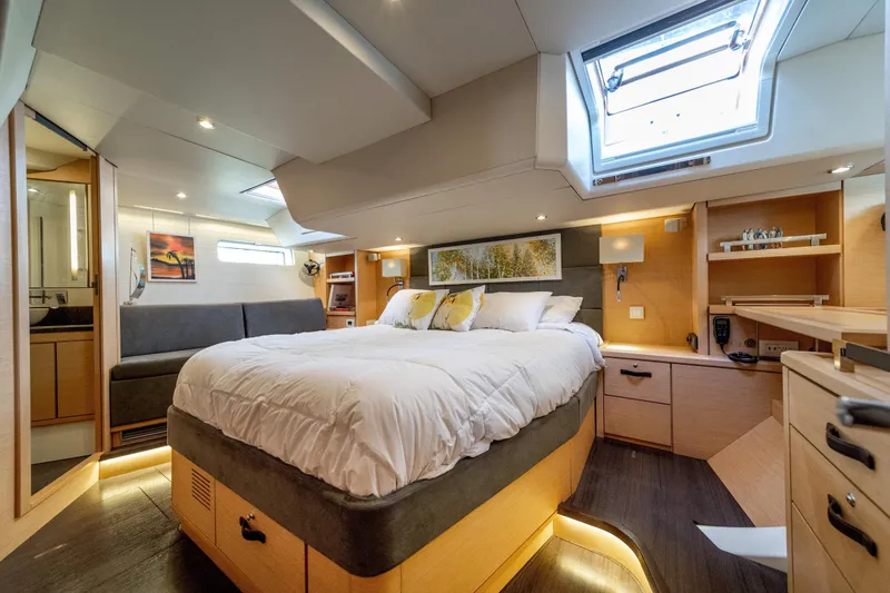 Slide: The Image of Luxurious 2016 Jeanneau 64 yacht bedroom with skylight, modern decor, and cozy ambiance. - 34