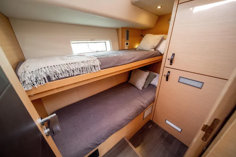Slide: The Image of Luxurious 2016 Jeanneau 64 yacht cabin with cozy bunk beds and modern design. - 41