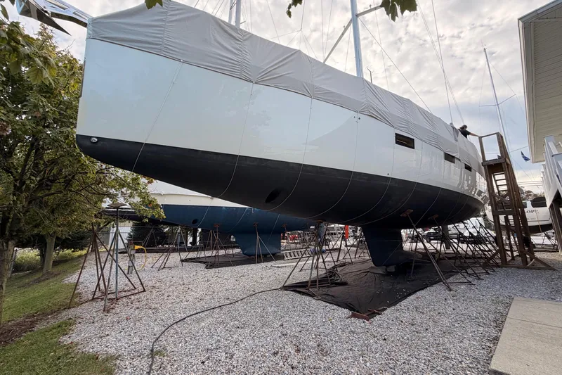 Slide: The Image of 2016 Jeanneau 64 yacht on dry dock, covered, with support stands. - 53