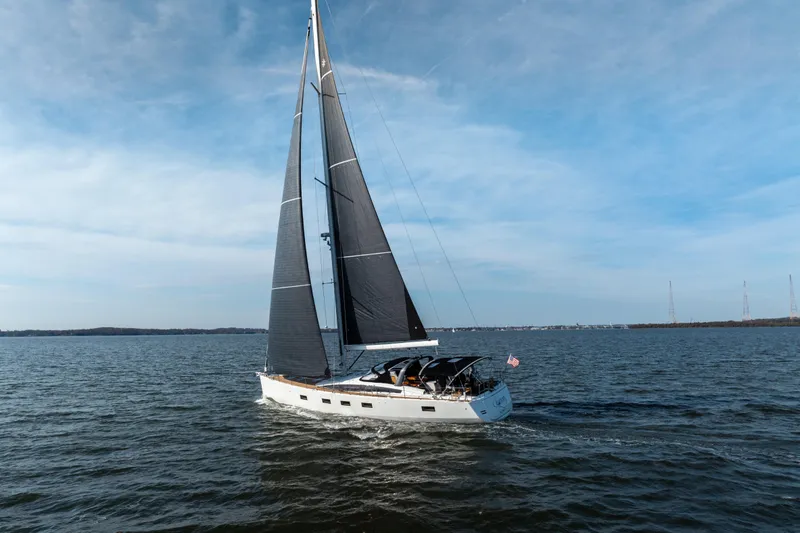 Slide: The Image of 2016 Jeanneau 64 sailboat cruising on open water under clear skies. - 7