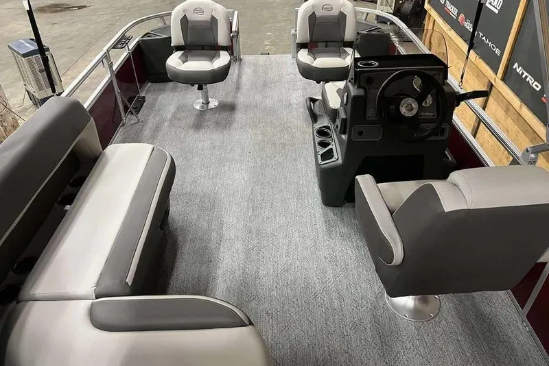 Slide: The Image of 2026 Sun Tracker Bass Buggy 18 DLX pontoon boat interior with seating and steering console. - 6