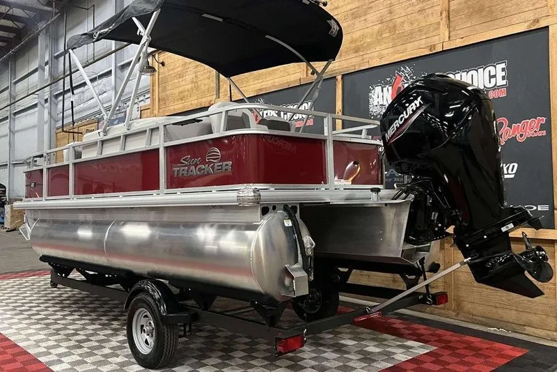 Slide: The Image of 2026 Sun Tracker Bass Buggy 18 DLX pontoon boat with Mercury outboard motor in showroom. - 8