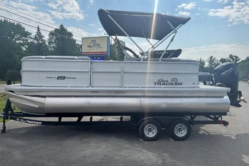 The Image of 2026 Sun Tracker PB 20 DLX pontoon boat on trailer, parked outdoors. - 1