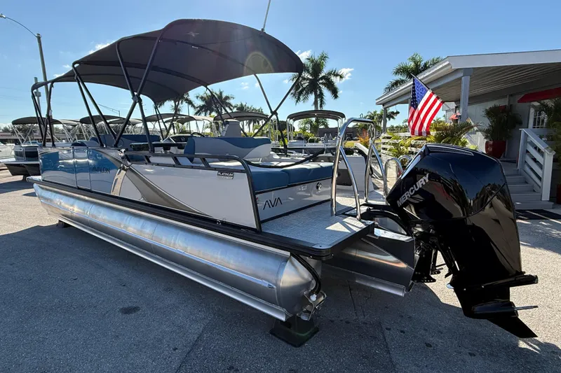 Slide: The Image of 2026 Avalon 2585 LSZ Entertainer Tri Toon boat with Mercury engine, docked outdoors. - 12