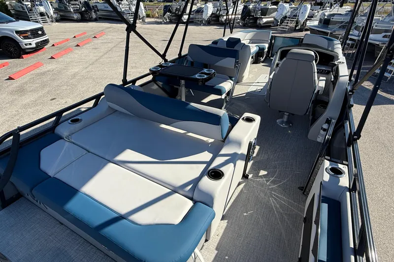 Slide: The Image of 2026 Avalon 2585 LSZ Entertainer boat interior with seating and helm, parked outdoors. - 13