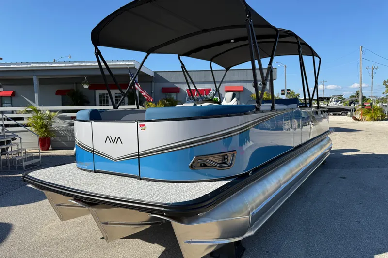 Slide: The Image of 2026 Avalon 2585 LSZ Entertainer Tri Toon boat with canopy, parked outdoors. - 3