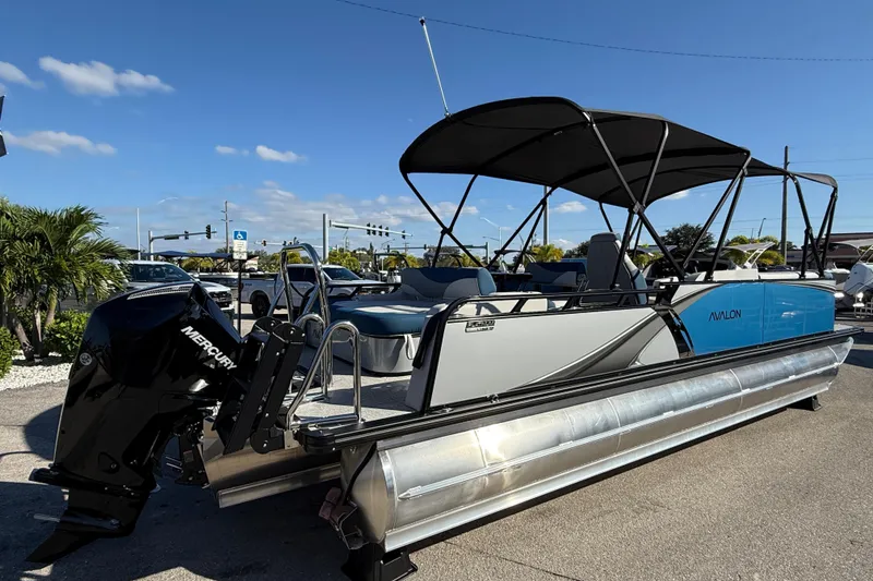 Slide: The Image of 2026 Avalon 2585 LSZ Entertainer Tri Toon boat with Mercury engine, parked outdoors. - 7