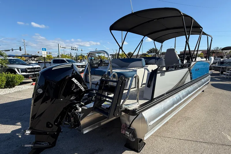 Slide: The Image of 2026 Avalon 2585 LSZ Entertainer Tri Toon boat with Mercury engine, parked outdoors. - 8