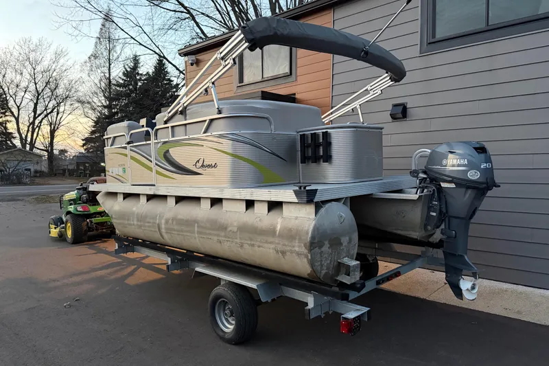 Slide: The Image of 2016 Qwest Adventure 7514 Cruise Deluxe pontoon boat on trailer, parked near house. - 10