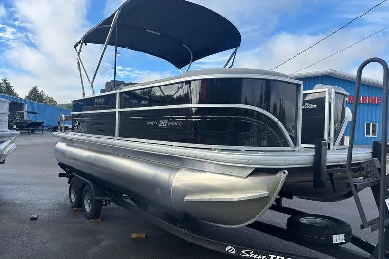 Slide: The Image of 2026 Sun Tracker Party Barge 20 DLX pontoon boat on trailer, under blue sky. - 3