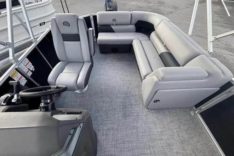 Slide: The Image of 2026 Sun Tracker Party Barge 20 DLX interior with gray seating and steering console. - 5