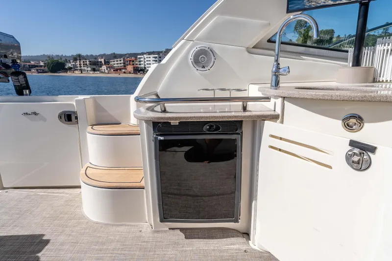 Slide: The Image of 2007 Sea Ray 48 Sundancer yacht deck with kitchenette and scenic waterfront view. - 17