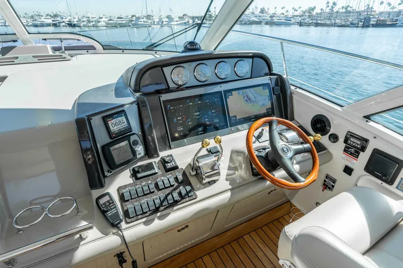 Slide: The Image of 2007 Sea Ray 48 Sundancer helm with advanced navigation and control systems, overlooking marina. - 20