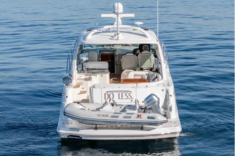 Slide: The Image of 2007 Sea Ray 48 Sundancer yacht on calm water, rear view with dinghy attached. - 3
