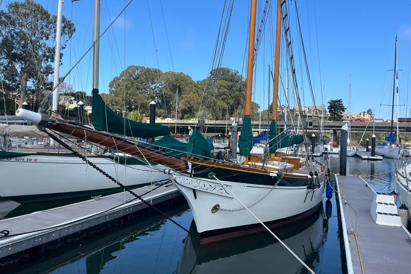The Image of Vintage 1947 Murray Peterson Schooner docked at a marina under clear blue skies. - 1