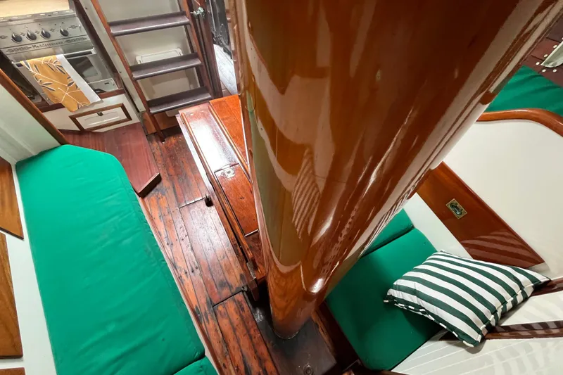 Slide: The Image of Interior of 1947 Murray Peterson Schooner with wooden floors and green seating. - 103