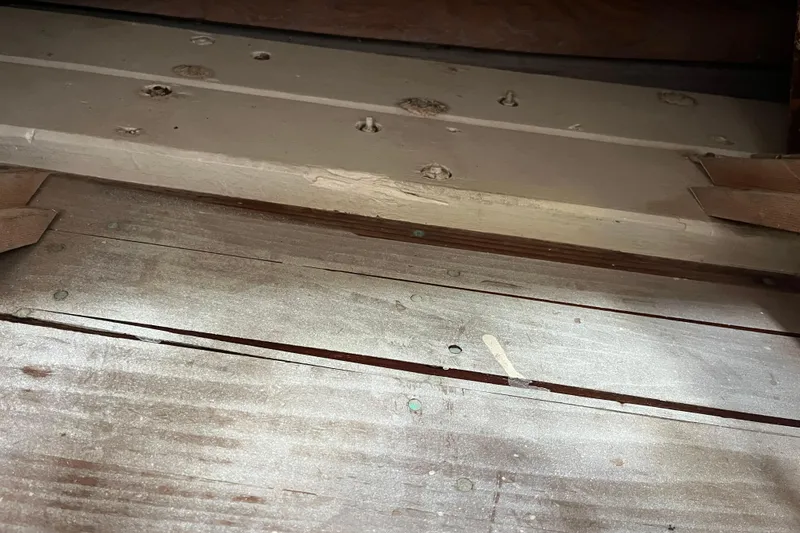 Slide: The Image of Wooden deck of 1947 Murray Peterson Schooner, showing aged planks and fastenings. - 130