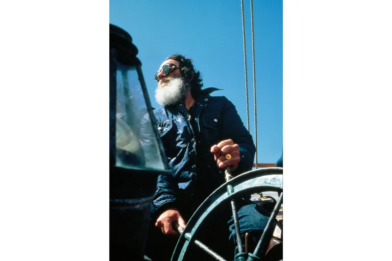 Slide: The Image of Man steering 1947 Peterson Schooner under clear blue sky. - 145