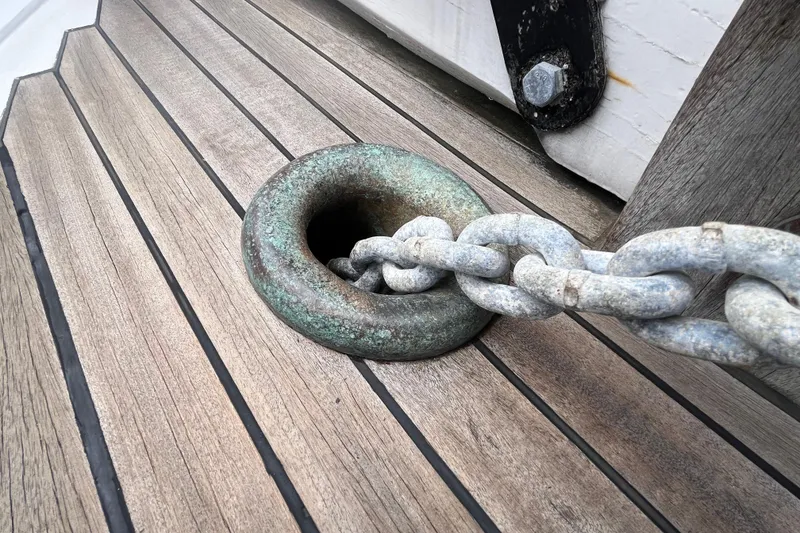 Slide: The Image of Chain passing through a metal ring on a 1947 Murray Peterson Schooner's wooden deck. - 20