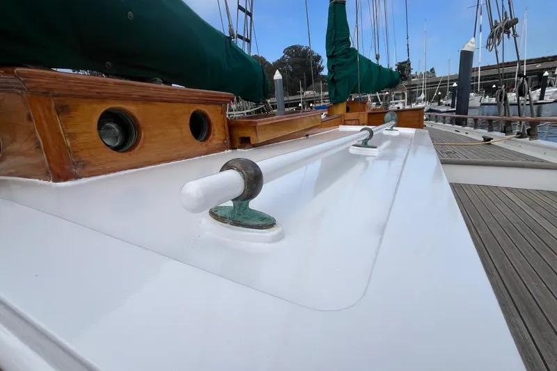 Slide: The Image of 1947 Murray Peterson Schooner deck with polished wood and green sail covers. - 24