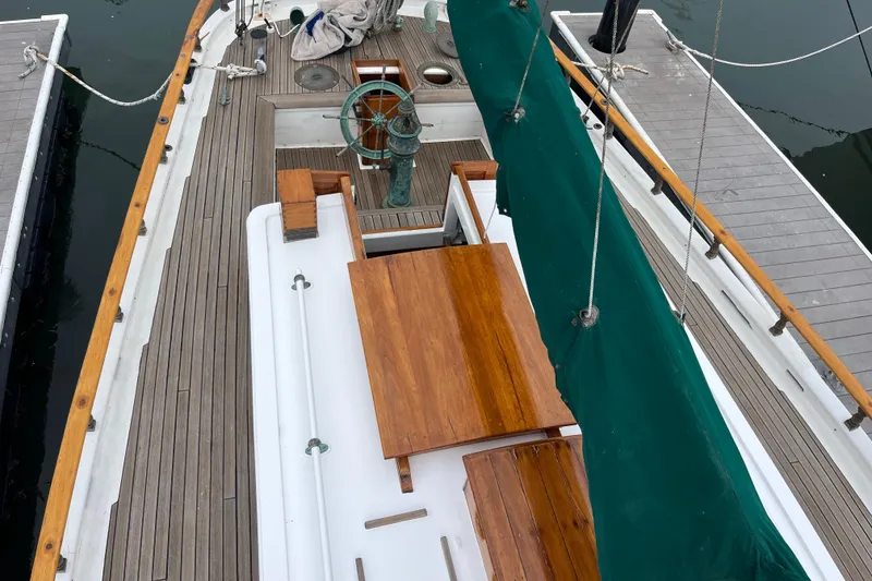 Slide: The Image of 1947 Murray Peterson Schooner deck with wooden table and green sail cover. - 31