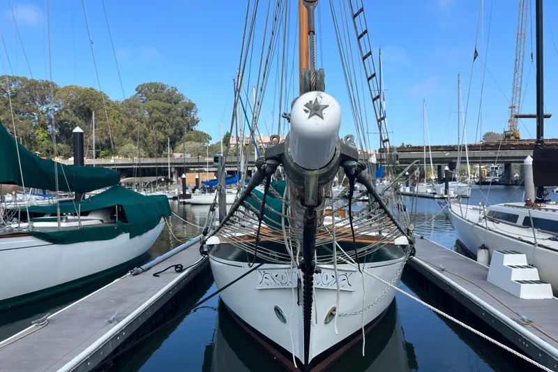 Slide: The Image of 1947 Murray Peterson Schooner docked at a marina, surrounded by other boats. - 4