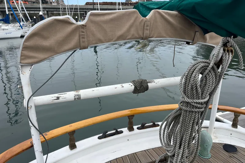Slide: The Image of 1947 Murray Peterson Schooner deck with ropes and railing at a marina. - 44