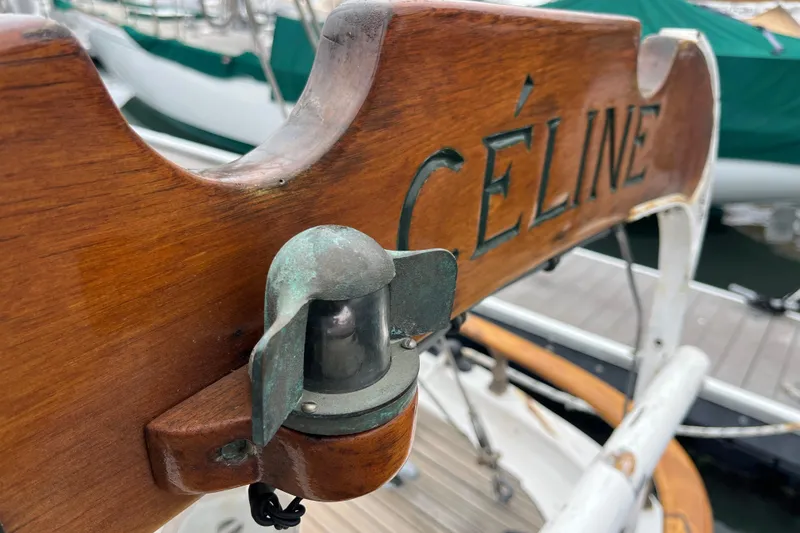Slide: The Image of Wooden nameplate on 1947 Murray Peterson Schooner, featuring "CÉLINE" and a vintage light fixture. - 45