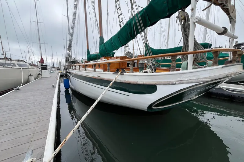Slide: The Image of Vintage 1947 Murray Peterson Schooner docked at marina, showcasing classic wooden design. - 50